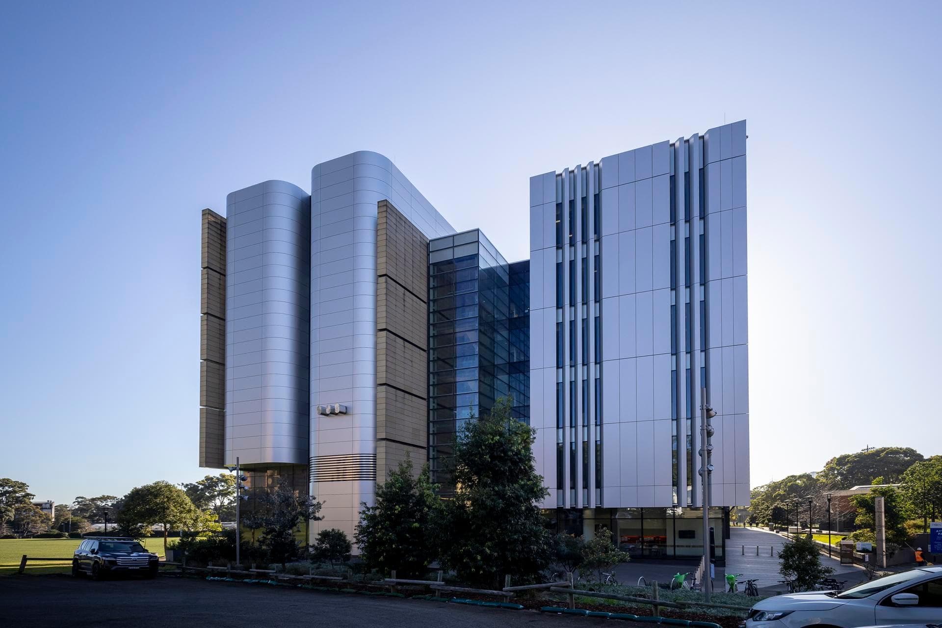 Close-up of Alpolic NC silver curved panels at the Charles Perkins Centre, showcasing smooth architectural detailing.
