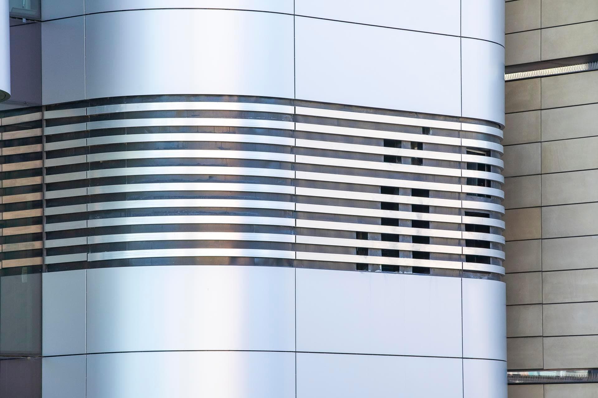 Rear façade of the Charles Perkins Centre clad in Alpolic NC beige and silver panels with large window sections.