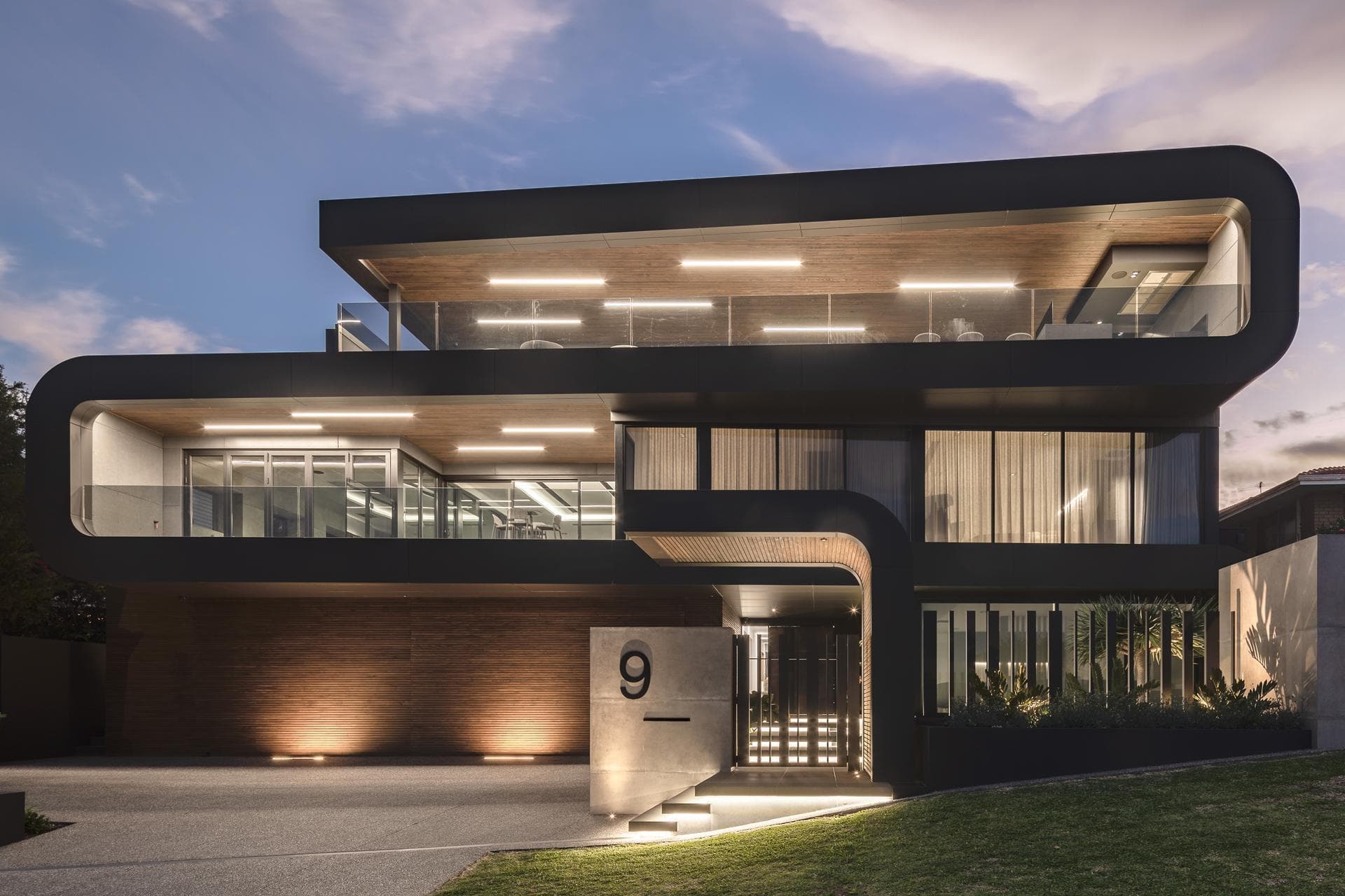 Evening façade view of 9 Stoke Street showcasing ALPOLIC™/fr Matte Slate Black cladding and curved balconies